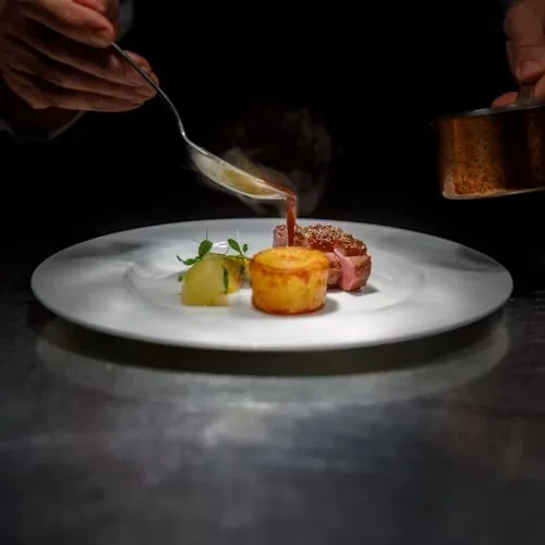 Maison Orée chef finishing a signature dish